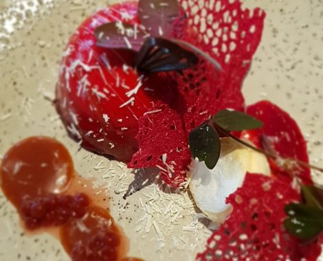 Mousse af hindbær og passion i chokoladeovertrukket hindbærkuppel, sprøde kys og karamel